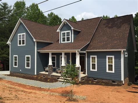 blue house with brown metal roof|brown siding house.